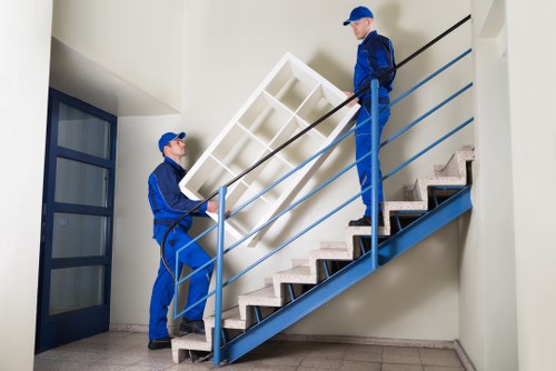 Professional movers carrying furniture in a Hounslow flat