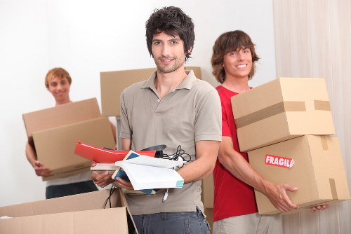 Professional movers carrying furniture in a Hounslow property